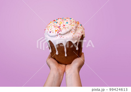 Easter holiday sweet bread kulich on hands on pink Easter holiday sweet bread kulich on hands on pink 99424613