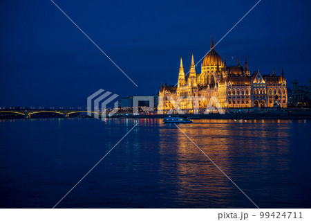 Illuminated Hungarian Parliament building and Margit Hid, Margaret Bridge night-time view with reflection in Danube river, Budapest, Hungary. Illuminated Hungarian Parliament building and Margit Hid, Margaret Bridge night-time view with reflection in Danube river, Budapest, Hungary. 99424711