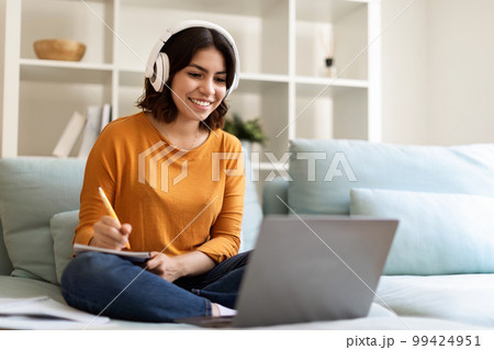 Young Arab Woman In Headset Study Online With Laptop From Home Young Arab Woman In Headset Study Online With Laptop From Home 99424951