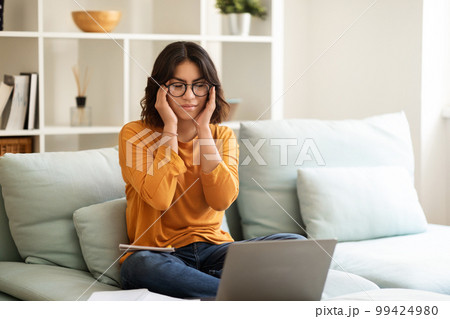 Tired Young Arab Woman Suffering Headache While Study With Laptop At Home 99424980