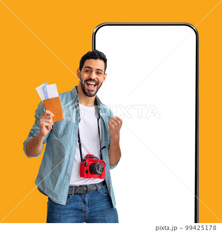 Excited middle eastern guy going vacation, gesturing on yellow 99425178