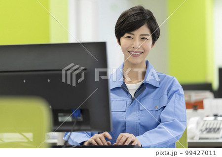 デスクワーク　作業服の若い女性 99427011