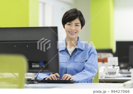 デスクワーク　作業服の若い女性 99427066
