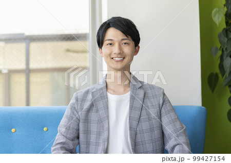 カメラ目線で笑顔の若い男性 ポートレート カメラ目線で笑顔の若い男性 ポートレート 99427154