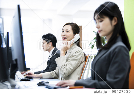 ビジネス　オフィス　電話　女性　通話　笑顔 99427359