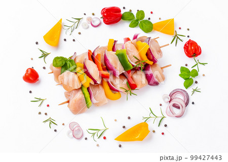 Chicken Skewers breast fillet meat.Uncooked mixed meat skewer.Skewers with pieces of raw meat,red,yellow,green pepper.Top view.Raw chicken skewers with vegetables,peppers,onions,on a white background. 99427443