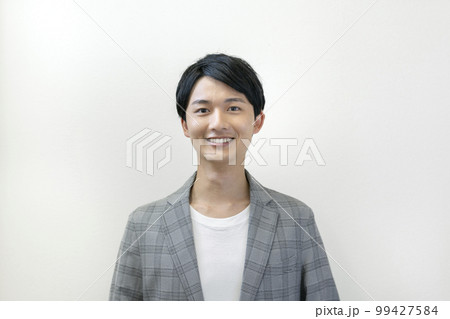 カメラ目線で笑顔の20代の男性　ポートレート 99427584