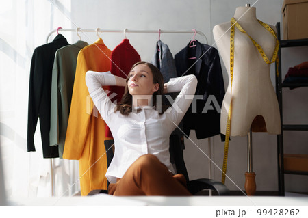 Beautiful young professional stylist working at design studio interior. fashion designer concept 99428262