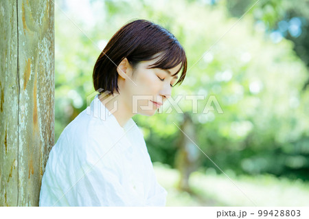 新緑の公園に気分転換に来た落ち込む女性 99428803