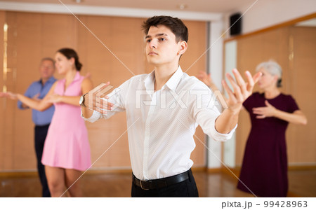 Confident young male dancer practicing ballroom dances in ballroom Confident young male dancer practicing ballroom dances in ballroom 99428963