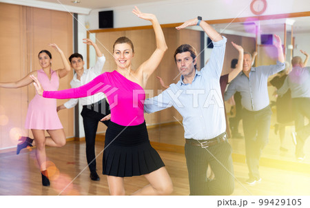 Happy couple performing a paired dance in ballroom 99429105