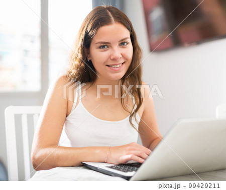 Young woman working on laptop at home 99429211