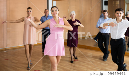 Young girl learning to dance kizomba in dancing class 99429441