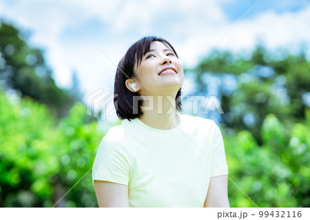新緑の中で音楽を聴く女性 新緑の中で音楽を聴く女性 99432116