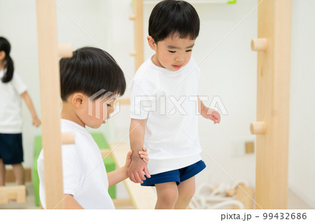 手を繋いでお世話する年長さん 99432686