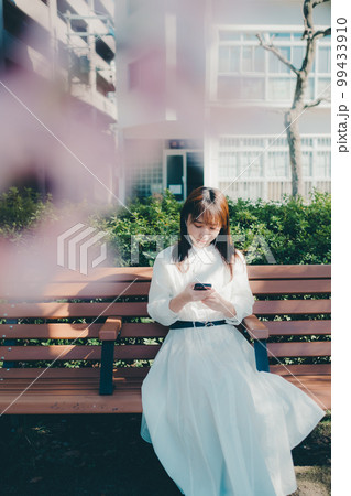 公園で音楽聴く若い女性の写真 99433910
