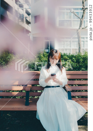 公園で音楽聴く若い女性の写真 公園で音楽聴く若い女性の写真 99433912