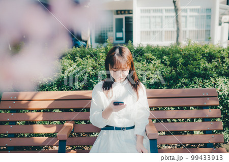 公園で音楽聴く若い女性の写真 99433913