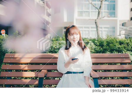 公園で音楽聴く若い女性の写真 99433914