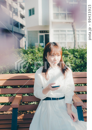 公園で音楽聴く若い女性の写真 99433915