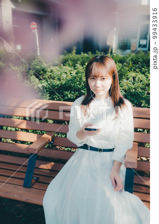 公園で音楽聴く若い女性の写真 99433916