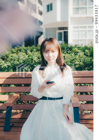 公園で音楽聴く若い女性の写真 99433917