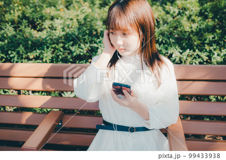 公園で音楽聴く若い女性の写真 99433938