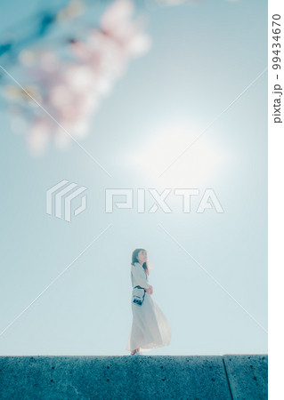 浜辺に佇む若い女性の写真 99434670