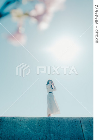 浜辺に佇む若い女性の写真 99434672