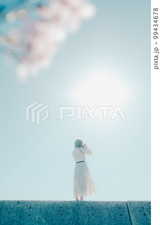 浜辺に佇む若い女性の写真 99434678