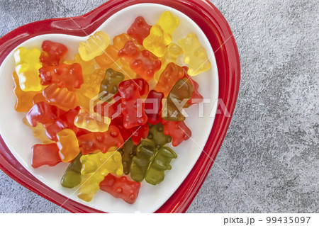 Teddy bear shaped jelly beans on a heart shaped plate Teddy bear shaped jelly beans on a heart shaped plate 99435097