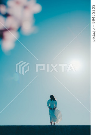 浜辺に佇み本を持っている若い女性の写真 浜辺に佇み本を持っている若い女性の写真 99435205