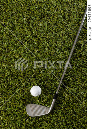High angle view of white golf ball and golf club on grass with copy space High angle view of white golf ball and golf club on grass with copy space 99435698