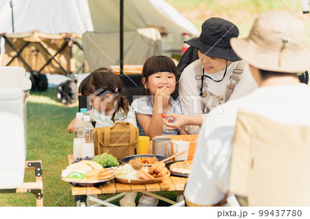 キャンプ場でバーベキュー・キャンプ飯を食べる家族(アウトドア・旅行・レジャー・ピクニック) キャンプ場でバーベキュー・キャンプ飯を食べる家族(アウトドア・旅行・レジャー・ピクニック) 99437780