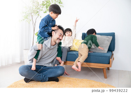 休日の子どもたちにもみくちゃにわれるパパ 子育てはとても大変 休日の子どもたちにもみくちゃにわれるパパ 子育てはとても大変 99439222