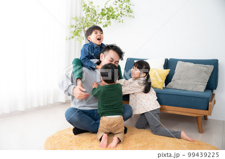 休日の子どもたちにもみくちゃにわれるパパ 子育てはとても大変 99439225