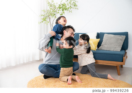 休日の子どもたちにもみくちゃにわれるパパ 子育てはとても大変 99439226