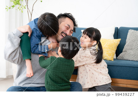 休日の子どもたちにもみくちゃにわれるパパ 子育てはとても大変 休日の子どもたちにもみくちゃにわれるパパ 子育てはとても大変 99439227