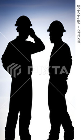 silhouette of worker at the construction site at sunset 99440460