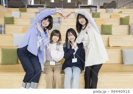 カジュアルビジネスイメージ　ハート型を作る若い女性たち 99440918