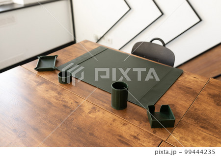 empty workplace in the office with leather green stationery accessories 99444235