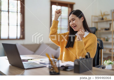 Young happy woman using laptop and celebrating victory and success, have good news, job celebrating achievement. 99446068