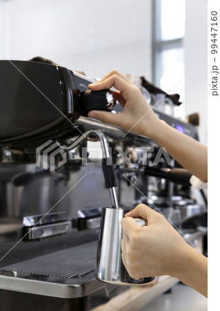 barista steaming milk for cafe latte in cafe barista steaming milk for cafe latte in cafe 99447160