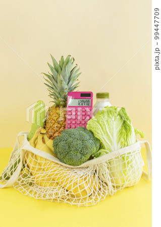 conceptual creative photo of monetary inflation, economic recession, crisis_full shopping basket and calculator 99447709