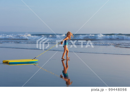 Young surfer girl with bodyboard has fun on sea beach 99448098