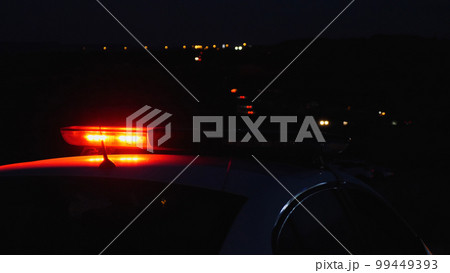 Close-up of a police blinker. The red rotating beacon on the roof of a police patrol car flashes brightly in the dark. Safety on the roads and protection of people. Close-up of a police blinker. The red rotating beacon on the roof of a police patrol car flashes brightly in the dark. Safety on the roads and protection of people. 99449393