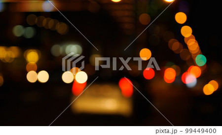 Blurred lights of the city at night and cars on the road. Multicoloured circles of light. 99449400