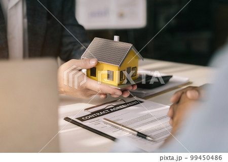 Real estate broker agent presenting and consult to customer to decision making sign insurance form agreement, home model, concerning mortgage loan offer. Real estate broker agent presenting and consult to customer to decision making sign insurance form agreement, home model, concerning mortgage loan offer. 99450486