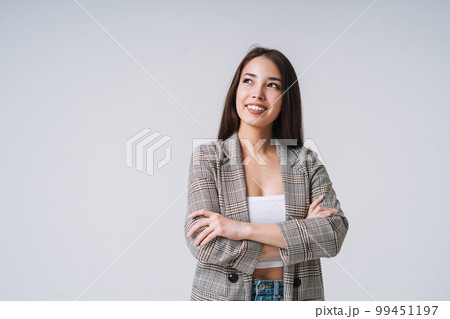 Young happy asian woman with long hair in suit on grey background Young happy asian woman with long hair in suit on grey background 99451197