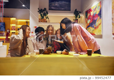 Multiracial happy young people eating pizza in pizzeria, black and white cheerful mates laughing enjoying meal having fun sitting together at restaurant table, diverse friends share lunch at meeting Multiracial happy young people eating pizza in pizzeria, black and white cheerful mates laughing enjoying meal having fun sitting together at restaurant table, diverse friends share lunch at meeting 99452477